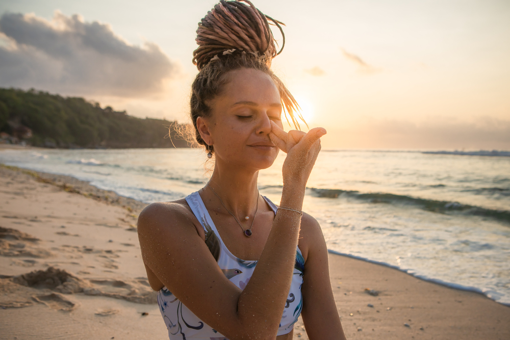 woman doing pranayama at beach