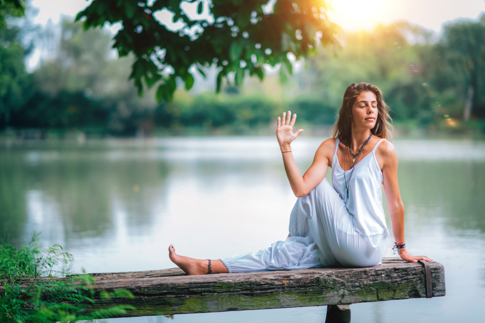 Girl in white attire having calm face while doing yoga retreat at Kaivalyam